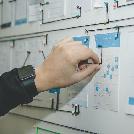 person working on blue and white paper on board